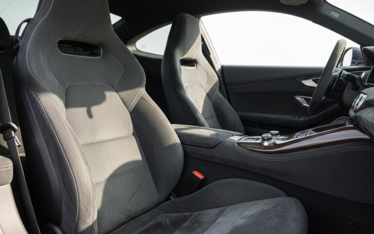 Intérieur de voiture de luxe avec sièges en tissu Alcantara, mettant en avant la texture et le confort.